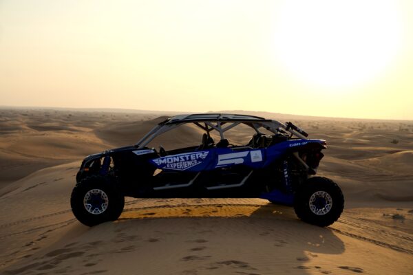 Blue Monster Experience Dune Buggy Parked on a sand dune in the Dubai Desert at sunset