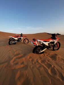 two motorbikes parked on the sand