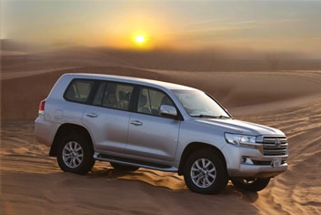 silver color 4X4 vehicle in the desert, photo taken from the right side during sunset