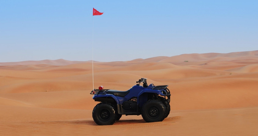 Blue Yamaha Grizzly kept at the desert in Dubai 