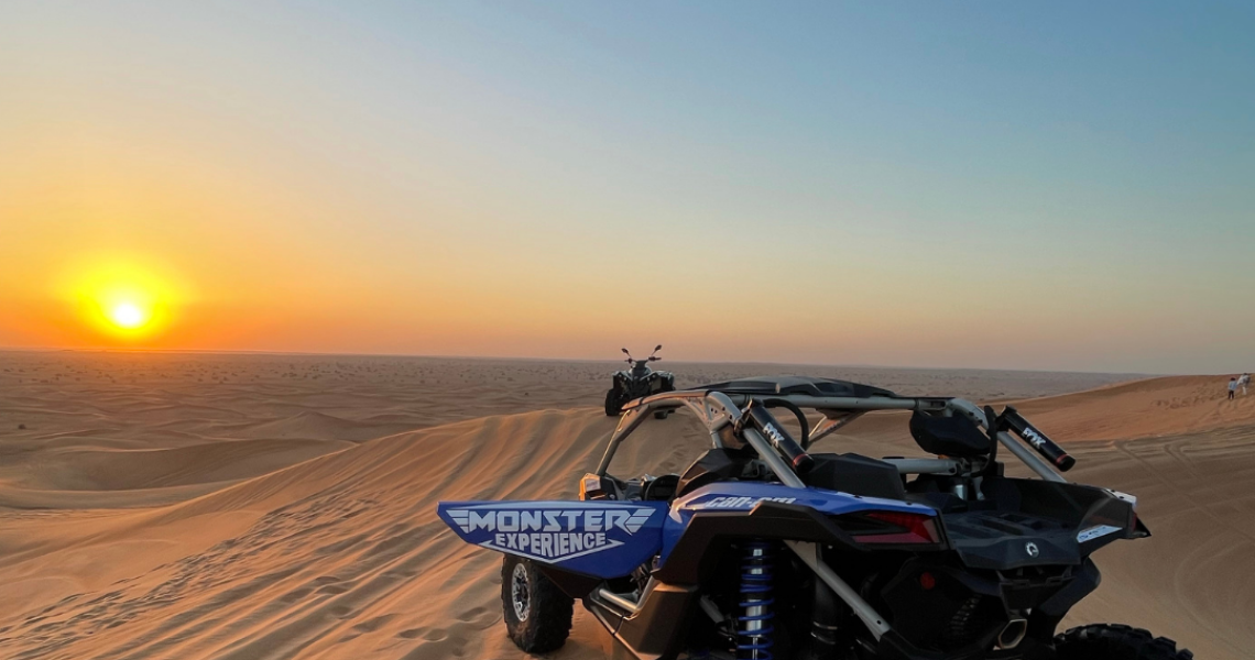 Dune buggy parked on a sand dune in Dubai during sunset