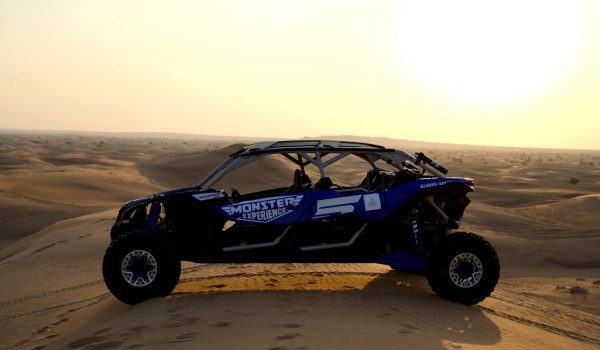 Blue Monster Experience Dune Buggy Parked on a sand dune in the Dubai Desert at sunset