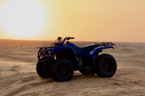 Monster Experience Yamaha Grizzly 350cc Quad Bike parked on a sand dune in the Dubai Desert at sunset