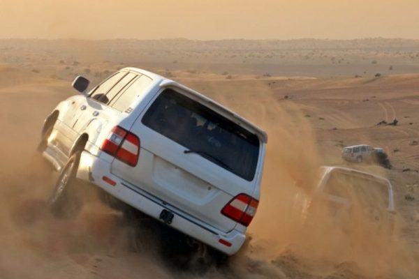 4x4 vehicles riding over sand Dunes on a desert safari in Dubai